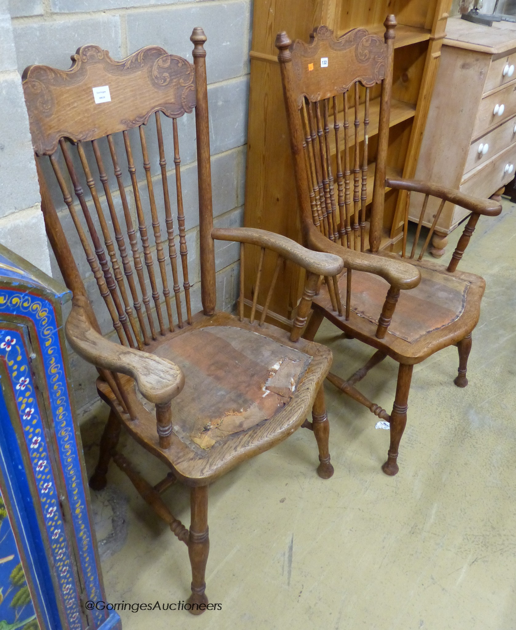 A pair of early 20th century American oak spindle back elbow chairs